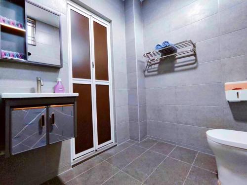 a bathroom with a toilet and a sink and a mirror at TREX Homestay_Batu Pahat in Batu Pahat