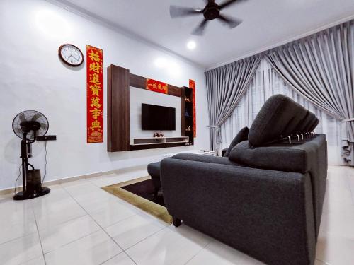 a living room with a couch and a tv at TREX Homestay_Batu Pahat in Batu Pahat