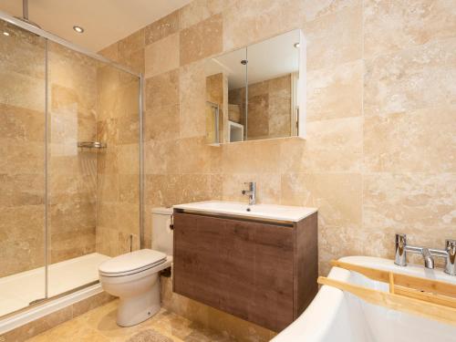 La salle de bains est pourvue de toilettes, d'un lavabo et d'une douche. dans l'établissement Walton House Cottage, à Chapel-en-le-Frith