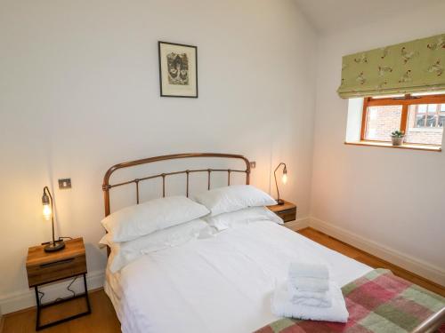 1 dormitorio con cama blanca y ventana en The Stables, en Preston