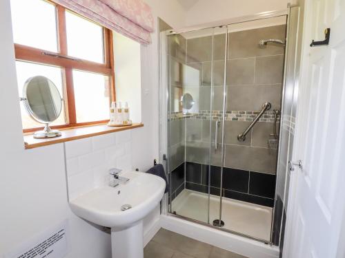 a bathroom with a shower and a sink and a toilet at The Stables in Preston