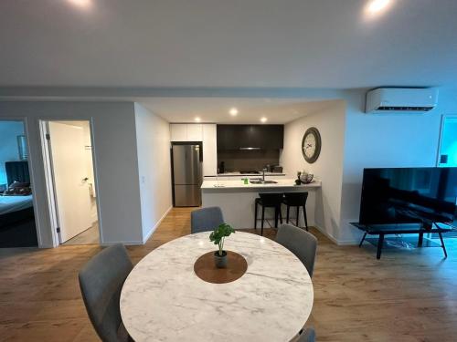 Una sala de estar con una mesa y una cocina. en Cozy 3BR Apartment Walking Distance to GOMA, en Brisbane