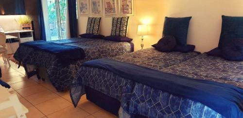 a bedroom with two beds with blue comforters at For U 2 Stay in Pretoria