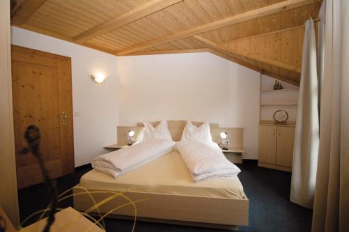 a bedroom with a bed with white sheets and pillows at Apartment Obkircher in Nova Levante