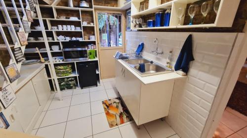 a small white kitchen with a sink and shelves at For U 2 Stay in Pretoria