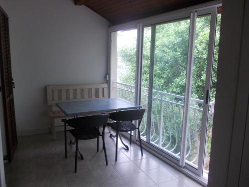 a table and chairs in a room with a large window at Apartmani Crkvina in Gradac