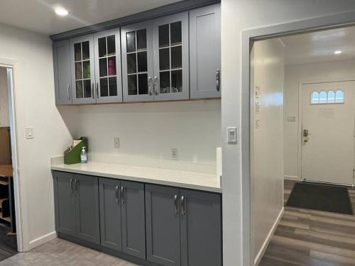 una cucina con armadi grigi e piano di lavoro di Affordable Private Rooms with Shared Bath Kitchen near SFO (SA) a Daly City
