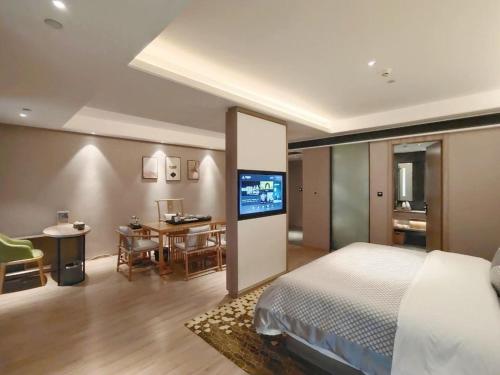 a bedroom with a bed and a table and a television at Morning Hotel, Changsha Yanghu New City Metro Station in Changsha