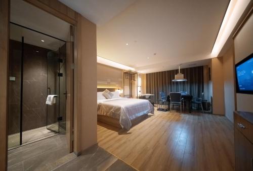 um quarto de hotel com uma cama e uma televisão em Luyuan Hotel, Shunde Plaza em Ningyuan