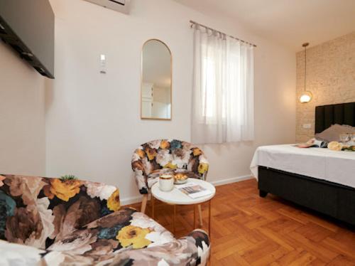 - un salon avec un lit, une table et des chaises dans l'établissement Guesthouse Ana Trogir Old Town, à Trogir