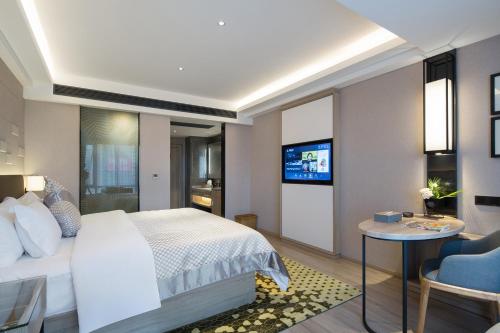 a hotel room with a bed and a tv at Morning Hotel, Changsha Yanghu New City Metro Station in Changsha