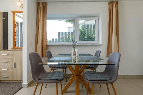 a dining room with a glass table and chairs at Bazalt Apartman in Badacsonytomaj