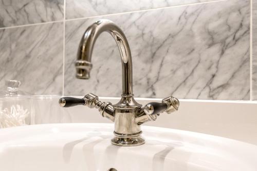 a bathroom sink with a silver faucet at Spacious, Calm One Bedroom in London