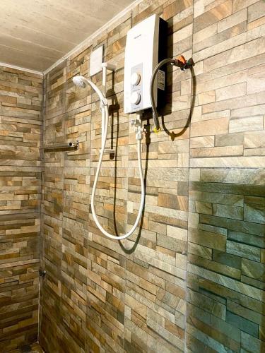 y baño con ducha y pared de piedra. en Moonlight Villa, en Phnom Penh
