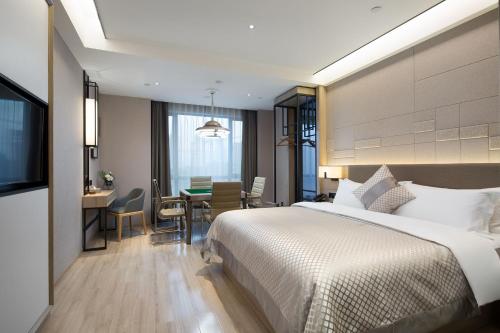 a hotel room with a bed and a dining room at Morning Hotel, Changsha Yanghu New City Metro Station in Changsha