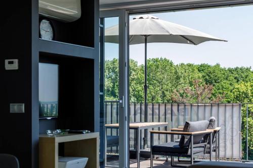 a patio with a table and an umbrella at Bazalt Apartman in Badacsonytomaj