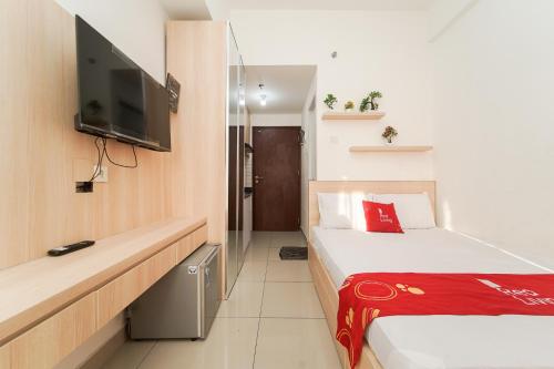 RedLiving Apartemen Sayana - Premium Property في Tambun-lobangbuaja: غرفة فندقية بسريرين وتلفزيون بشاشة مسطحة