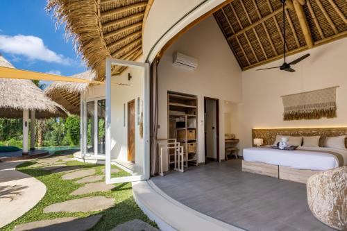 een slaapkamer in een villa met een bed en een patio bij Villa Kizmet Fit by BaliSuperHost in Ubud