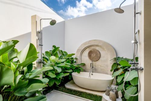 een badkamer met een bad en groene planten bij Villa Kizmet Fit by BaliSuperHost in Ubud