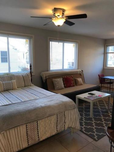 a bedroom with two beds and a couch and a ceiling fan at Walk2Metro's,DCGem,Private,Wifi, FreeParking in Arlington