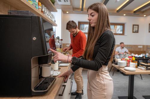 a woman pointing at a computer in a store at Veldes B&B in Bled