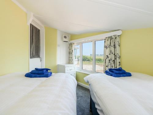 dwa łóżka w pokoju z oknem w obiekcie The Sir Peter Scott Lighthouse w mieście Spalding