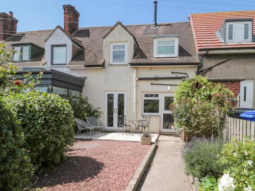a house with a patio in front of it at 3 St Cuthberts Garth in Bamburgh