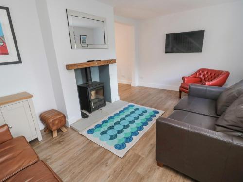 a living room with a couch and a fireplace at 3 St Cuthberts Garth in Bamburgh