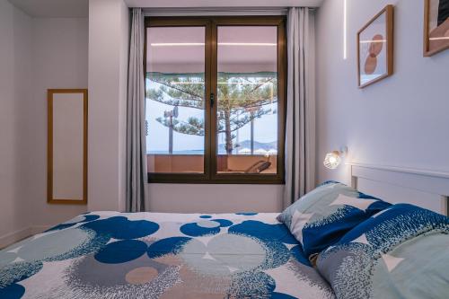 sypialnia z łóżkiem i widokiem na okno w obiekcie 1linea Canteras w mieście Las Palmas de Gran Canaria