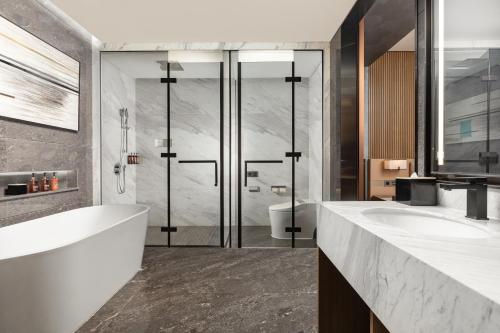 a bathroom with two sinks and a tub and a shower at Wyndham Garden Shenzhen Longhua in Shenzhen