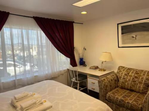 a hotel room with a bed and a desk and a chair at Affordable Private Rooms with Shared Bath Kitchen near SFO (SA) in Daly City
