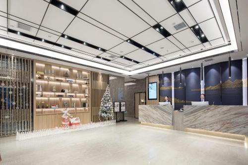 a lobby with a christmas tree and a checkout counter at Morning Hotel, Changsha Yanghu New City Metro Station in Changsha