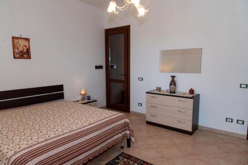 a bedroom with a bed and a dresser and a mirror at Il Rustico di Pino in Custonaci