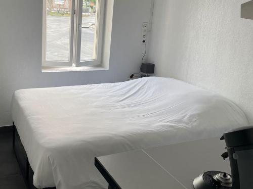 un lit blanc dans une chambre avec une fenêtre dans l'établissement Studio1 proche Fac climatisé, à Albi