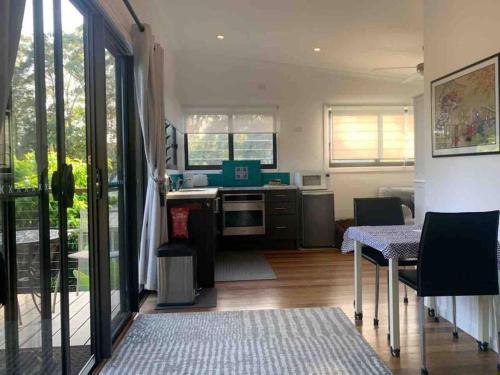 uma cozinha com uma mesa e uma sala de jantar em Coffs Harbour Sanctuary em Coffs Harbour