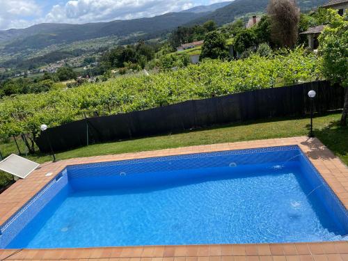 a blue swimming pool with a view of a hill at Chalet casa con piscina en ARBO Vigo in Arbo