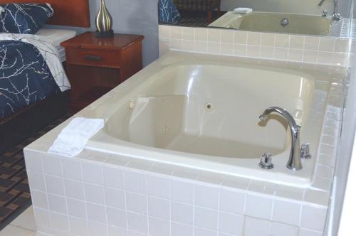 a white bath tub with a faucet in a bathroom at Americas Best Value Inn and Suites St. Cloud in Saint Cloud