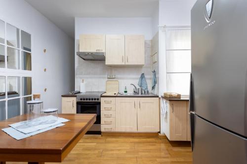 a kitchen with a wooden table and a refrigerator at EDEN RENTALS Cozy City Central Apartment in Santa Cruz de Tenerife