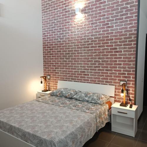 a bedroom with a brick wall and a bed at LOFT 85 in Baia Verde