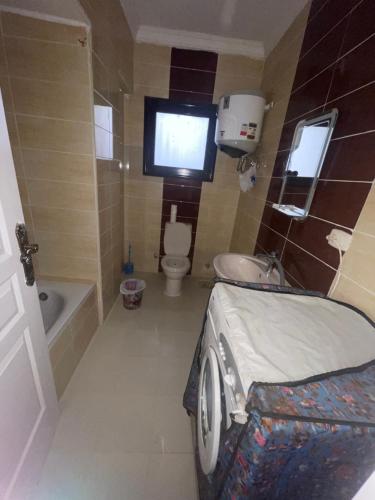 a small bathroom with a bed and a tv in it at فيلا في بلو باي أسيا العين السخنة in Ain Sokhna