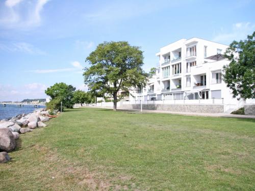 a large white building next to a body of water at Ostseeresidenz Sassnitz F548 WG 7 mit Sauna, Terrasse, Meerblick in Sassnitz
