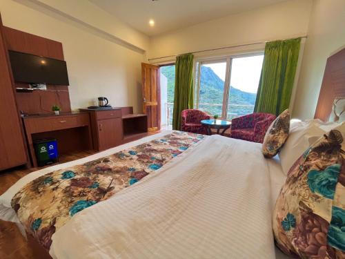 um quarto com uma cama grande e uma janela grande em Hotel Kempty - A Boutique Hotel, Mussoorie em Mussoorie