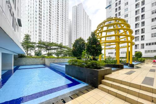 a swimming pool in a city with tall buildings at RedLiving Apartemen Bassura City - Premium Property in Jakarta