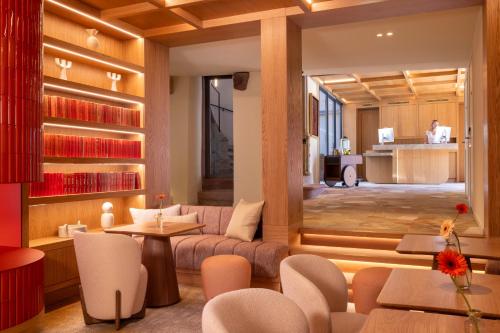 a living room with a couch and a table and chairs at Hotel Le Colombier in Colmar