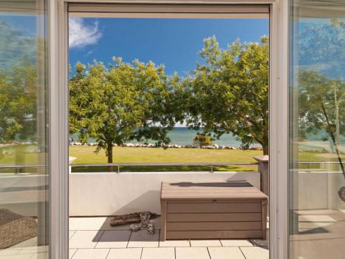 Une porte coulissante en verre s'ouvre sur un balcon offrant une vue sur l'océan. dans l'établissement Ostseeresidenz Sassnitz F548 WG 7 mit Sauna, Terrasse, Meerblick, à Sassnitz