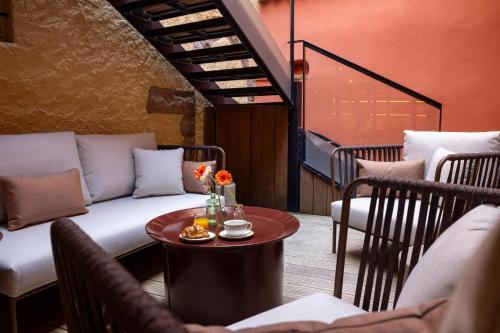 a living room with a couch and a table at Hotel Le Colombier in Colmar