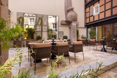 a patio with tables and chairs in a building at Hotel Le Colombier in Colmar
