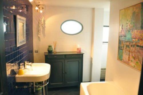 La salle de bains est pourvue d'un lavabo, d'une baignoire et d'une fenêtre. dans l'établissement Loft sur les toits d'arles, à Arles