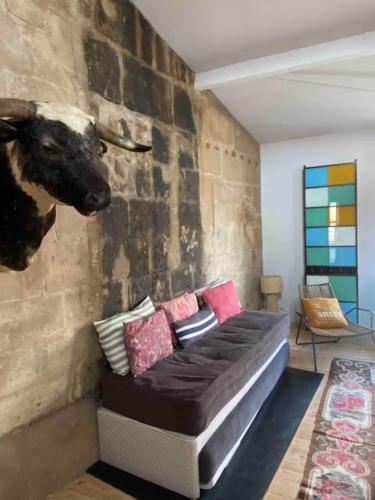 un salon avec un canapé avec une tête de vache sur le mur dans l'établissement Loft sur les toits d'arles, à Arles