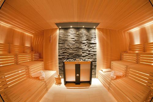 a sauna with a stone wall and a tv in it at Hotel Fliana Ischgl in Ischgl